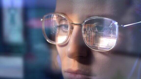研究外骨骼原型的女科学家电脑屏幕反射在眼镜上