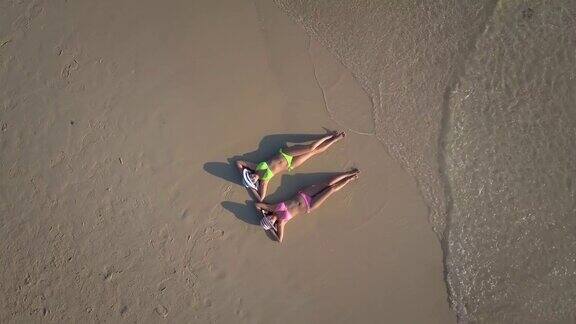 两个年轻女子在海滩上晒太阳鸟瞰图
