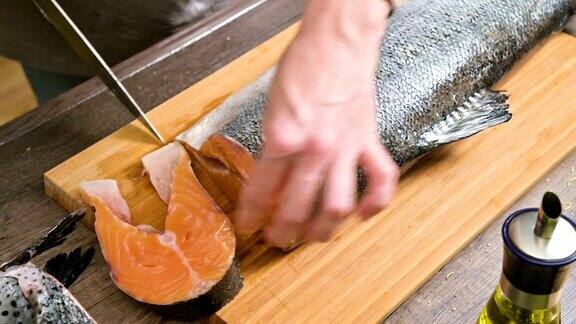 女性的手正在用刀切一条大鲑鱼