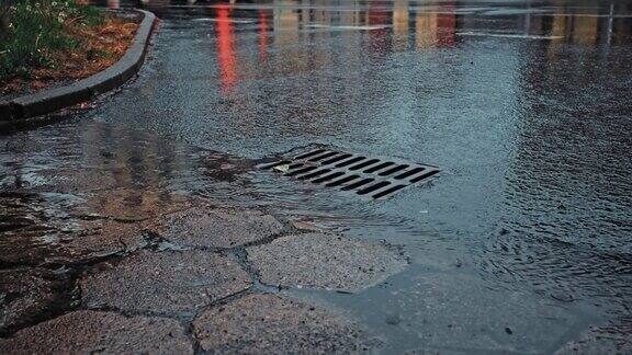 雨水顺着街道雨水下水道排水口流下