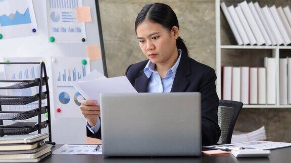 商务女性在办公室工作笔记本电脑和文件在桌子上