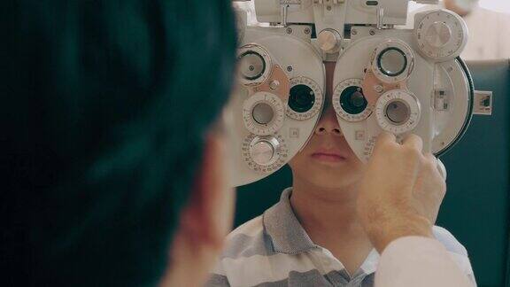 眼科医生检查男孩的视力与光镜-股票视频