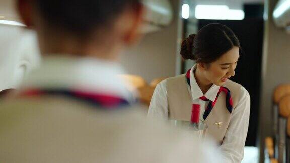 在飞机上为乘客提供食物和饮料的4K亚裔女空姐