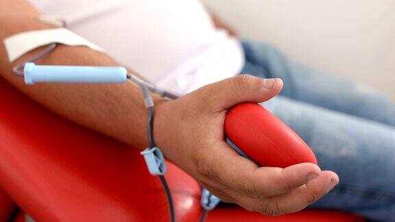 好事为身体献血的好处接受输血者的手献血者在医疗诊所献血的特写