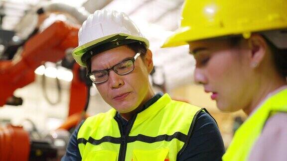 4K亚洲男女工程师在建筑工地操作机械臂