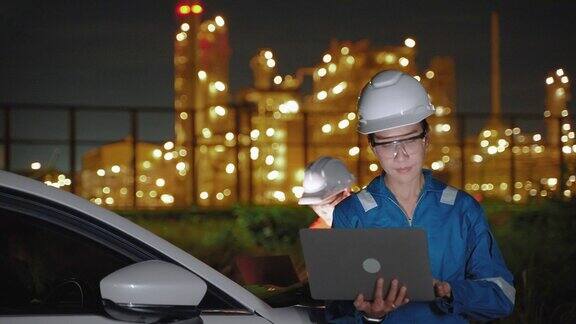 亚洲女性检验工程师在晚上用笔记本电脑检查炼油厂和炼油厂的生产质量研究和开发能源生产