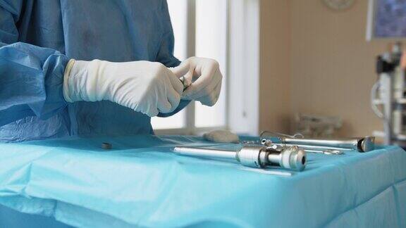 一张桌子上放着医疗工具为机器人手术做准备外科手术工具套件手术外科医生的手在准备手术用的器械