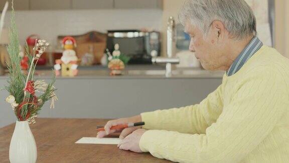 一名日本老人正在写新年贺卡
