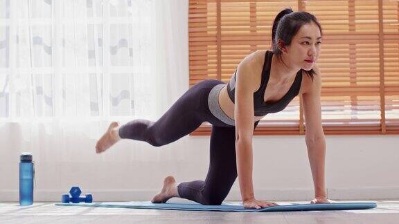 运动健康的亚洲年轻妇女在运动服装锻炼腿在家里锻炼年轻女性与苗条的身体有氧运动健康健康的生活健康的生活方式