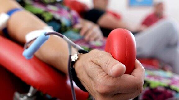 好事为身体献血的好处接受输血者的手献血者在医疗诊所献血的特写