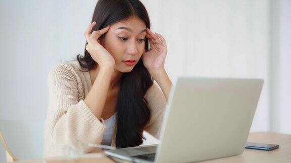 办公室综合症劳累过度的年轻亚洲妇女在电脑工作后感到头痛有视力问题压力大的年轻女子在家饱受疲劳之苦