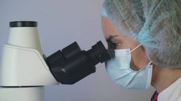 医学发展实验室:女科学家在显微镜下观察分析生物样本