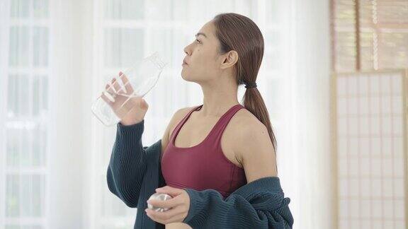 女人在家做瑜伽时喝水