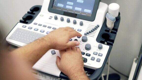 特写医生的手在超声波扫描仪上工作医务人员使用特殊设备