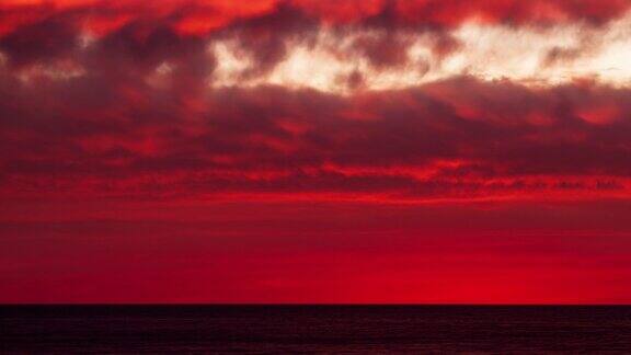 当太阳从太平洋升起时天空中出现了明亮的火红色云彩