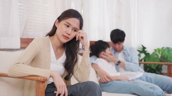 亚洲女人和丈夫吵架后坐在客厅倍感压力父亲坐下来拥抱儿子鼓励他离婚法家庭问题概念