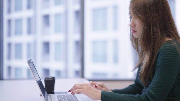 亚洲年轻的商务女性在办公室会议室使用笔记本电脑工作