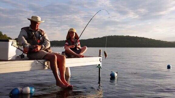 爷爷和孙子在夏天夕阳下钓鱼