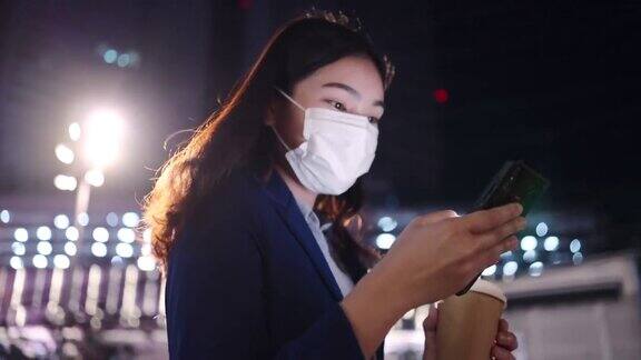 亚洲女商人使用平板电脑她一边在城市里散步一边喝咖啡