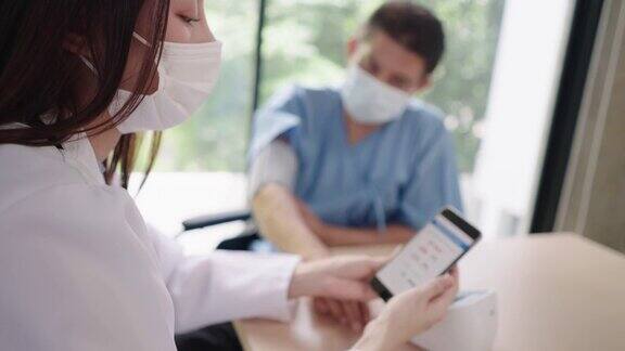危险健康的老人高血压病通过手机app检查医生在智能手机屏幕上检查病人的血压水平进行测量越过医生的肩膀查看