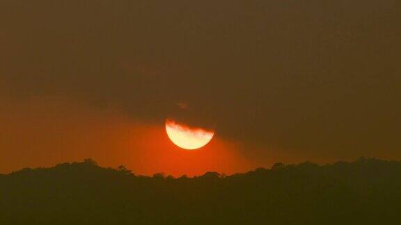 一个巨大的橙色太阳落在山上的时间流逝