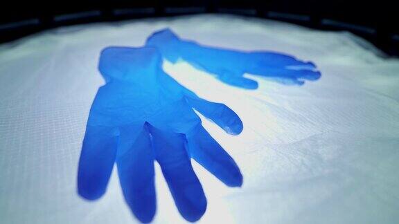 手术灯上的蓝色医用手套救人医生的手套