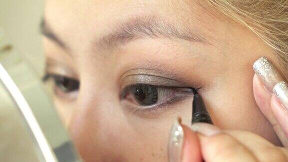女性使用眼线化妆美容