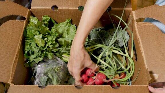 手从农贸市场打开一盒新鲜的时令有机蔬菜