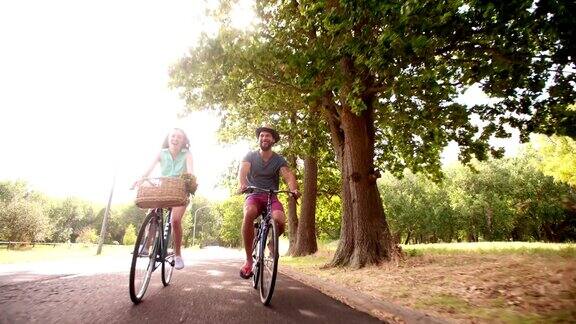一对年轻夫妇在公园里骑自行车