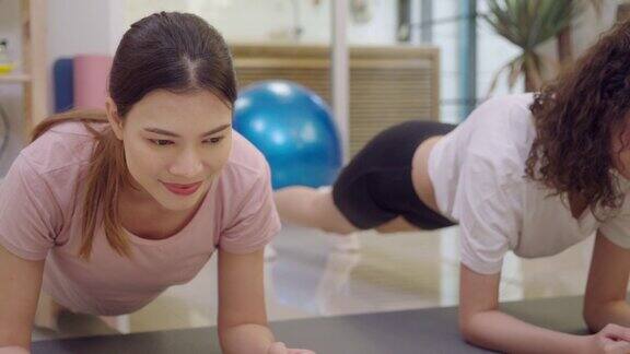 健康的亚洲妇女和妹妹摆平板支撑位置在线重量训练