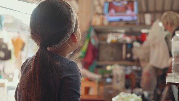 后景:亚洲女孩坐在电视机前