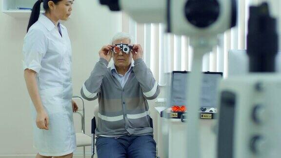 眼科医生为老年病人试戴测试眼镜