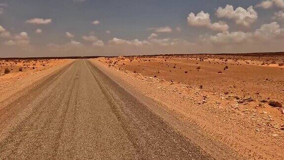 在阳光明媚的日子里开车穿过突尼斯干旱的风景司机的视角