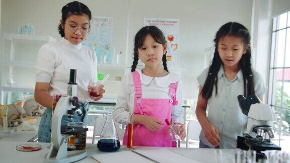 高中学生在放学后学习STEM教育他们在实验室里用显微镜检查和观察一些东西