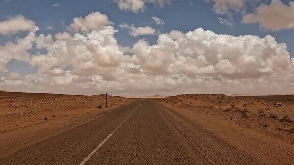 突尼斯沙漠景观和蓬松的云为背景司机的观点