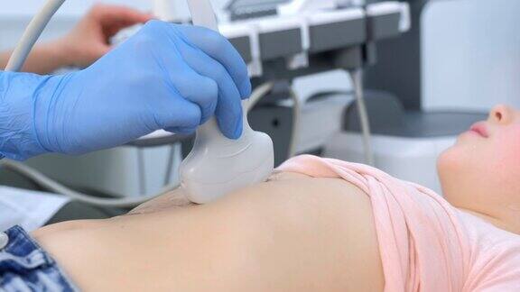 医生正在用扫描仪给一个女孩做腹部超声侧视图