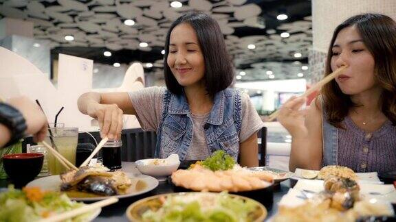 亚洲女性吃日本料理寿司三文鱼生鱼片用筷子愉快地在日本餐厅