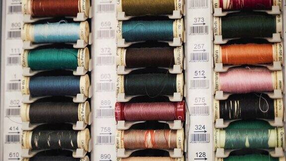 裁缝车间的一排排彩色棉线线轴专业缝纫机的线卷纺织工业的织物线缝纫工具材料和设备