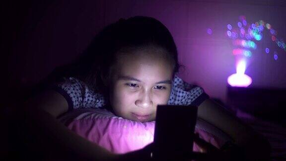 漂亮女孩在床上用智能手机