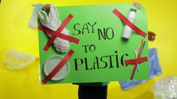女孩活动家拿着绿色海报说不塑料塑料自然污染