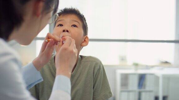 耳鼻喉科医生检查亚洲男孩的喉咙