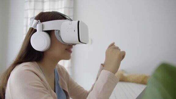 亚洲女性在家庭办公室使用VR眼镜