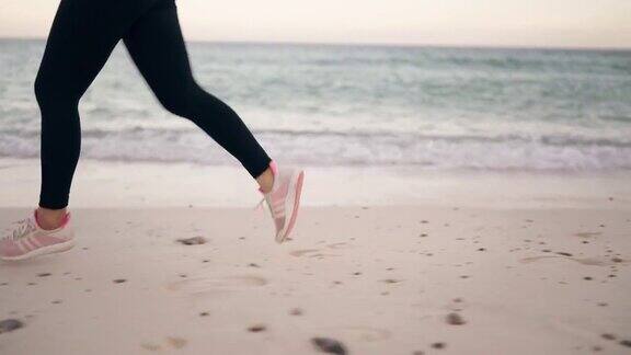 在沙滩上跑步的女跑步者的腿