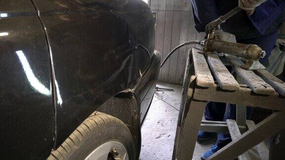 修车技师正在修理汽车的损坏部分