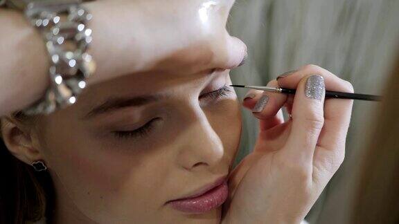 油漆的眼睛化妆师创造美丽的化妆金发模特美容和水疗中心