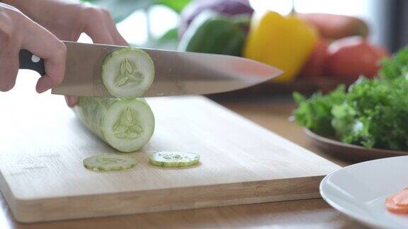 用锋利的刀在木板上切黄瓜的特写镜头