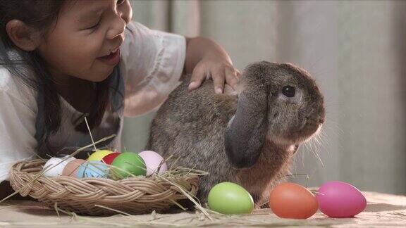 复活节课桌上一只灰色的兔子和快乐的孩子们在一起