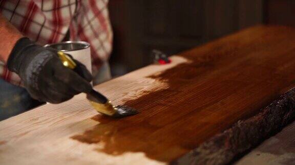 男子正在把棕色的漆涂在木板表面油漆铺子