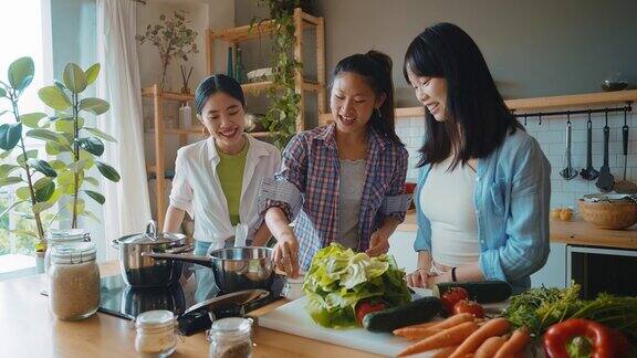 三个快乐的年轻女子在厨房准备亚洲食物