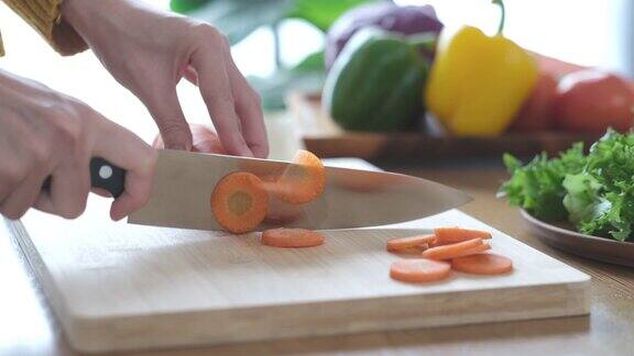 用锋利的刀在木板上切胡萝卜的特写镜头